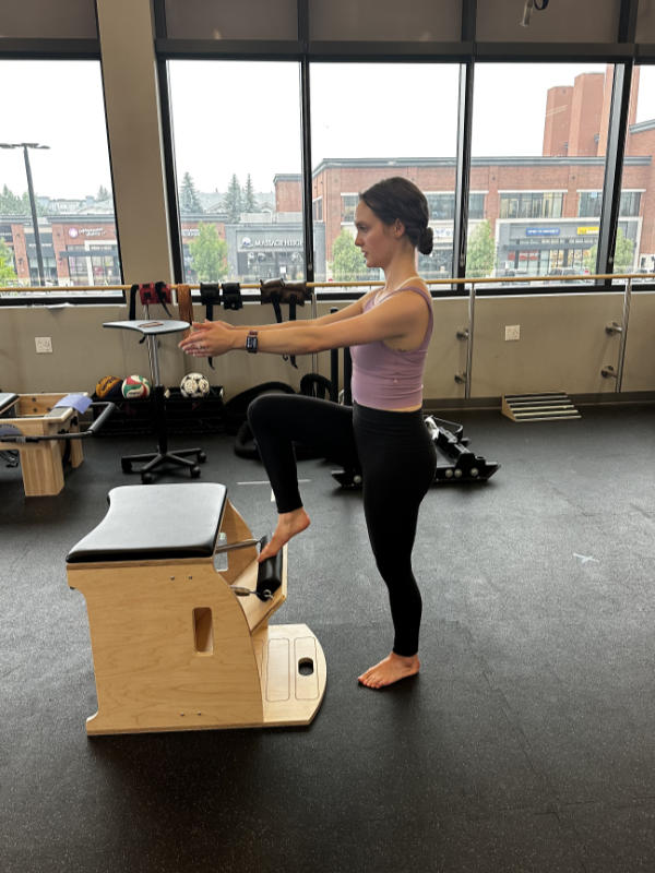 A clinical pilates exercise is shown, using the Wunda Chair.